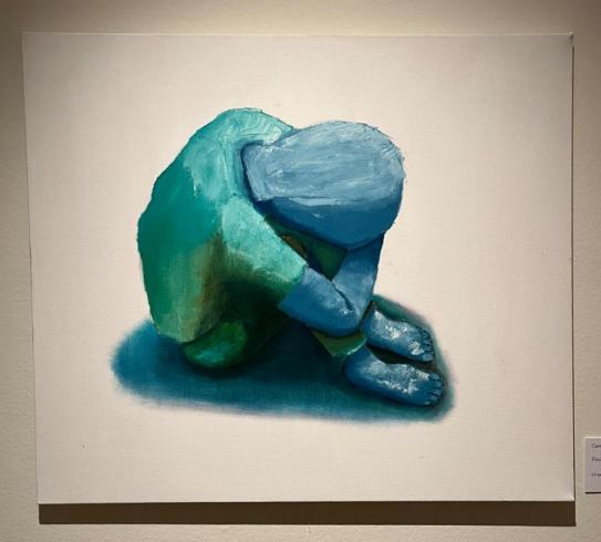Painting of an absract blue figure sitting on the ground with head and hands on knees