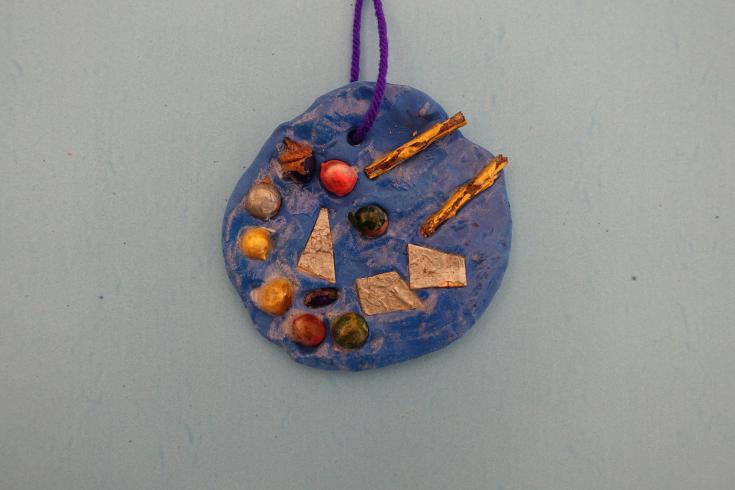 Clay mobile with painted holly and sticks.