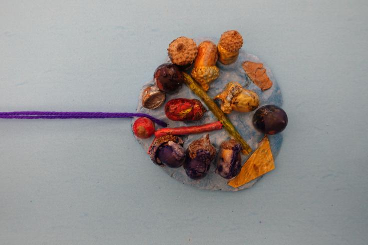 Clay mobile with painted acorns.