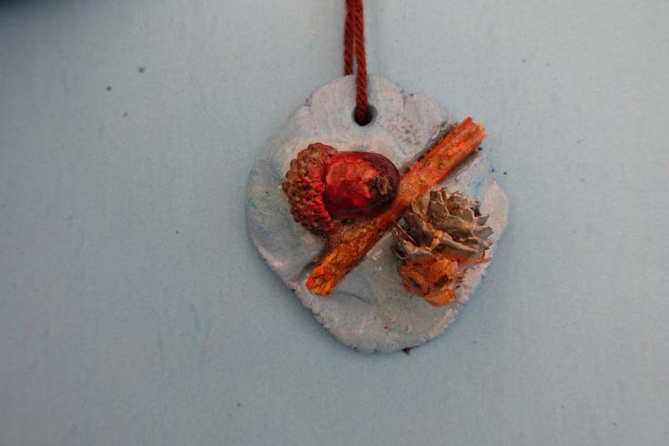 Clay mobile with a painted acorn and pinecone.