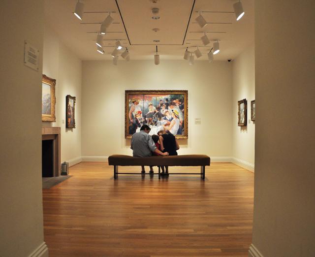 Photograph of a family looking at Renoir's Luncheon of the Boating Party