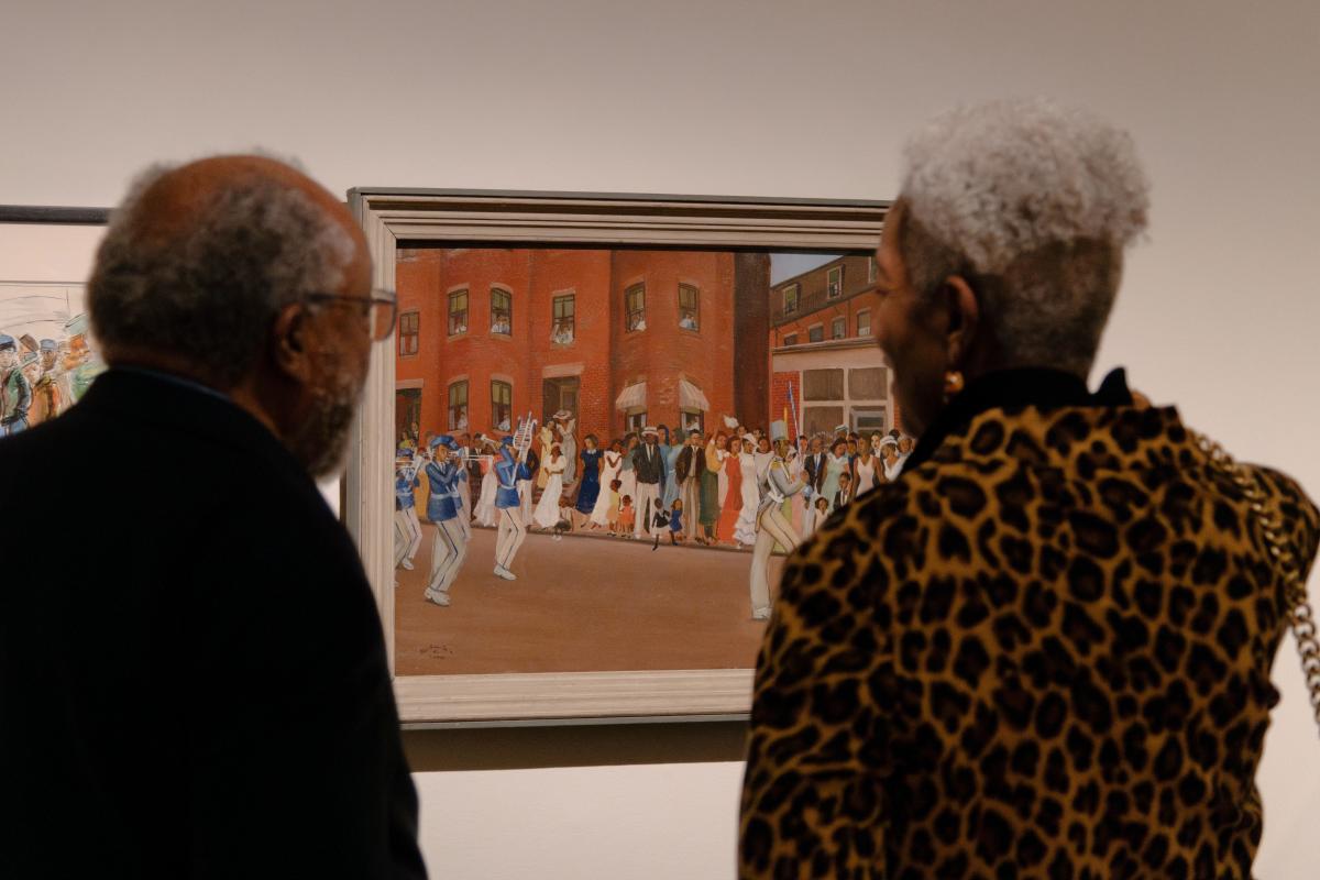 Two people looking at Allan Rohan Crite's Prade on Hammond Street