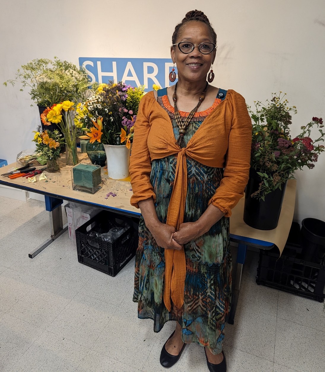 Karen Massalley in front of flowers in the art workshop