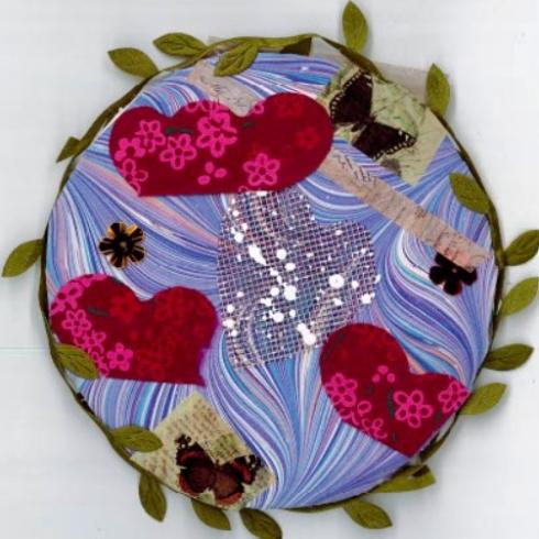 Circle with collage of red hearts, all outlined by a green vine.