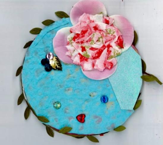 Circle with collage of a pink flower, all outlined by a green vine.