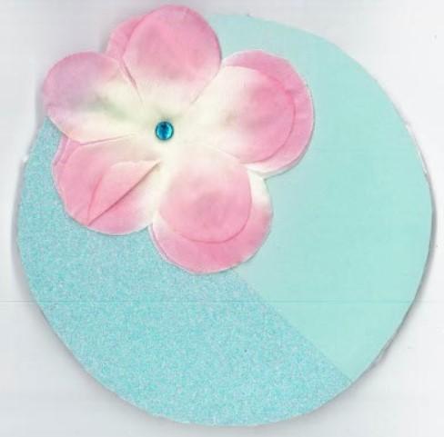 Circle with collage of a pink flower and blue background.