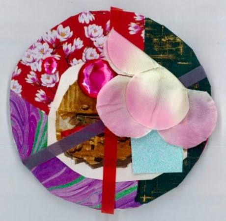 Circle with collage of red, pink, and purple paper and fabrics.