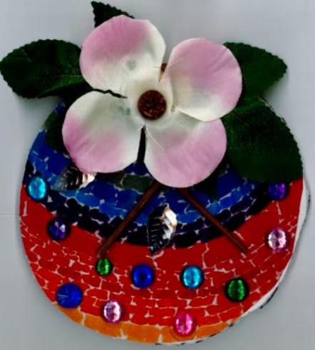 Circle with collage of a pink flower and colorful gems.