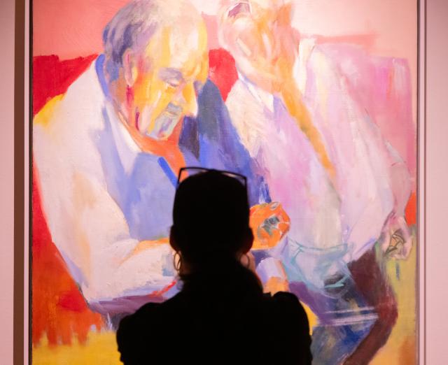 Woman standing in front of one of Vivian Brown's Little Men paintings