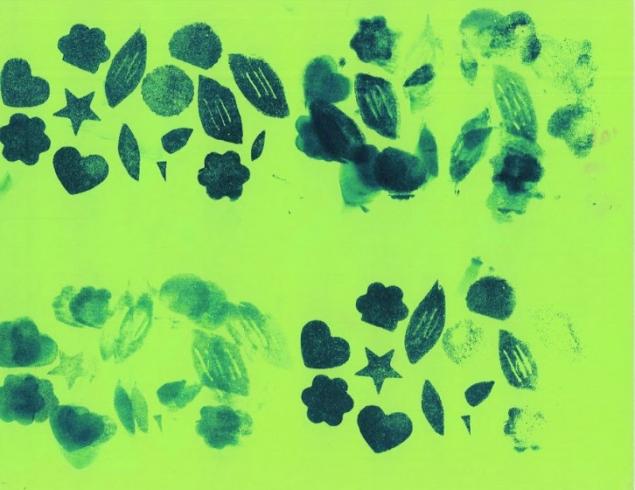 Dark green pattern stamped on light green paper.