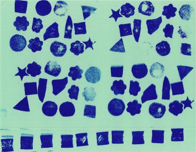 Blue shapes stamped on green paper.
